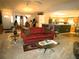 Inviting living room featuring a cozy red sofa and open floor plan to kitchen at 751 Old Oaks Ln, Leesburg, FL 34748