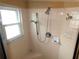 Bathroom shower with window featuring a handheld shower head, built-in seat, and tiled walls at 751 Old Oaks Ln, Leesburg, FL 34748