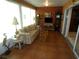 Sunny sunroom furnished with comfortable seating, a glass coffee table, and tile flooring at 751 Old Oaks Ln, Leesburg, FL 34748