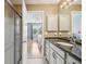 Bathroom with white cabinets, granite countertops, shower, and an open doorway to a bedroom at 8039 Se 174Th Belhaven Loop, The Villages, FL 32162