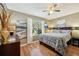 Comfortable bedroom with wood floors, large window, ceiling fan, and beautifully coordinated decor at 8039 Se 174Th Belhaven Loop, The Villages, FL 32162