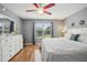 Cozy bedroom with hardwood floors, grey walls, white trim, and natural light from large window at 8039 Se 174Th Belhaven Loop, The Villages, FL 32162