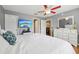 Bedroom with hardwood floors, ceiling fan, television and a large window letting in natural light at 8039 Se 174Th Belhaven Loop, The Villages, FL 32162