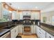 Updated kitchen features granite counters, stainless appliances, and white cabinets with black hardware at 8039 Se 174Th Belhaven Loop, The Villages, FL 32162