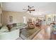 Comfortable living room with hardwood floors, fan, and open layout to the dining area at 8039 Se 174Th Belhaven Loop, The Villages, FL 32162