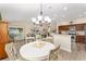 Bright dining area open to living spaces, featuring a chandelier and views of the kitchen and living room at 832 Parrish Pl, The Villages, FL 32163