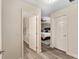 Hallway leading to bedroom with wood floors, neutral walls, and white doors creating a seamless transition at 832 Parrish Pl, The Villages, FL 32163
