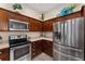 Well-equipped kitchen featuring stainless steel appliances, rich wood cabinetry, and stylish countertops at 832 Parrish Pl, The Villages, FL 32163