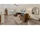 Spacious living room with comfortable seating, a ceiling fan, and views of the adjacent dining and kitchen areas at 832 Parrish Pl, The Villages, FL 32163