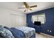 Bright bedroom features blue accent wall, large closet, and a ceiling fan at 8639 Se 141St Pl, Summerfield, FL 34491