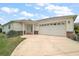 Charming single-story home features an attached two-car garage and a well-manicured front yard at 8639 Se 141St Pl, Summerfield, FL 34491