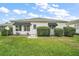 Charming white home with green awning accents, lush lawn, and well-maintained landscaping at 8639 Se 141St Pl, Summerfield, FL 34491