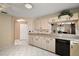 Well-lit kitchen with white tile flooring and cabinets with black hardware at 8639 Se 141St Pl, Summerfield, FL 34491