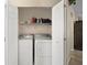 Convenient laundry closet featuring a washer, dryer, and storage shelf for all your laundry needs at 8639 Se 141St Pl, Summerfield, FL 34491