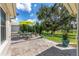 Outdoor living space with brick-paved patio, dining area, and lush landscaping at 9059 Se 177Th Grassmere St, The Villages, FL 32162