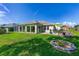 Landscaped backyard featuring a patio with outdoor seating and a well-manicured lawn at 9059 Se 177Th Grassmere St, The Villages, FL 32162