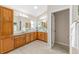 Well-lit bathroom featuring double sinks, granite counters, and ample cabinet storage at 9059 Se 177Th Grassmere St, The Villages, FL 32162