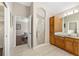 En-suite bathroom featuring a glass shower, wood cabinetry and tile floors at 9059 Se 177Th Grassmere St, The Villages, FL 32162