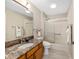 Well-lit bathroom featuring a granite countertop, modern fixtures, and a shower/tub combo with sliding glass doors at 9059 Se 177Th Grassmere St, The Villages, FL 32162