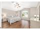 Bright bedroom featuring a large window, high ceiling, wood floors, and stylish décor at 9059 Se 177Th Grassmere St, The Villages, FL 32162