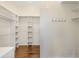 Spacious walk-in closet with custom shelving and hardwood floors for organized storage at 9059 Se 177Th Grassmere St, The Villages, FL 32162
