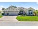 Attractive home boasts a three-car garage, manicured lawn, and charming front patio at 9059 Se 177Th Grassmere St, The Villages, FL 32162