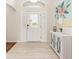 Welcoming foyer with tile floors, a decorative cabinet, and a view of the front door at 9059 Se 177Th Grassmere St, The Villages, FL 32162