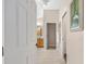 Hallway leading to bathroom with neutral paint, tile floors, and view of natural wood vanity at 9059 Se 177Th Grassmere St, The Villages, FL 32162