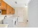 Bright laundry room featuring modern washer and dryer, ample storage space, and neutral tile flooring at 9059 Se 177Th Grassmere St, The Villages, FL 32162