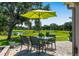 Outdoor patio area with an umbrella-covered table and chairs overlooking the golf course and lake at 9059 Se 177Th Grassmere St, The Villages, FL 32162