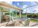 Enclosed patio featuring a seating area, golf course view, and sliding glass doors to the home's interior at 9059 Se 177Th Grassmere St, The Villages, FL 32162