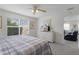 Cozy bedroom with large window, white dresser with TV, and view to living room at 9321 Se 172Nd Augusta Ln, The Villages, FL 32162