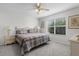 Bright bedroom features a ceiling fan, large window, and cozy plaid bedding at 9321 Se 172Nd Augusta Ln, The Villages, FL 32162