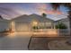 The home's exterior is beautifully illuminated at twilight, highlighting the white picket fence at 9321 Se 172Nd Augusta Ln, The Villages, FL 32162