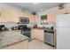 Bright kitchen with stainless steel appliances, granite countertops, and light wood cabinets at 9321 Se 172Nd Augusta Ln, The Villages, FL 32162