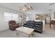 Comfortable living room with a black leather sofa, a coffee table, and natural light from the windows at 9321 Se 172Nd Augusta Ln, The Villages, FL 32162