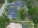 Aerial view of a backyard featuring a large lawn, fence, playground, and screened pool with patio at 9512 Mid Summer Ln, Leesburg, FL 34788