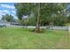 Spacious backyard features a playset, mature tree, seating, and white fence, perfect for outdoor enjoyment at 9512 Mid Summer Ln, Leesburg, FL 34788