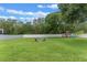 Expansive backyard features a fire pit and a playset, ideal for relaxation and outdoor activities at 9512 Mid Summer Ln, Leesburg, FL 34788