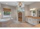 A luxurious bathroom with a soaking tub, a large window, a vanity and a separate shower at 9512 Mid Summer Ln, Leesburg, FL 34788