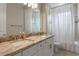 Beautiful bathroom featuring double sinks, marble countertops, modern faucets, and a shower-tub combo at 9512 Mid Summer Ln, Leesburg, FL 34788