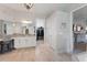 Well-lit bathroom featuring dual vanities, tile flooring, and doorways to the water closet and walk-in closet at 9512 Mid Summer Ln, Leesburg, FL 34788