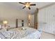 Relaxing bedroom with tray ceiling fan, double door closet and view to the ensuite bathroom and walk-in closet at 9512 Mid Summer Ln, Leesburg, FL 34788