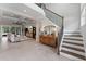 Grand foyer with staircase, decorative chandelier, and view into the spacious living area featuring a coffered ceiling at 9512 Mid Summer Ln, Leesburg, FL 34788