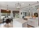 Bright, open kitchen with white cabinets, marble countertops, an island, and a breakfast nook with large windows at 9512 Mid Summer Ln, Leesburg, FL 34788