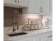 Kitchen counter featuring gray backsplash, stainless steel faucet, marble countertops and a coffee bar setup at 9512 Mid Summer Ln, Leesburg, FL 34788