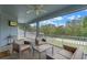 Screened-in lanai featuring outdoor seating area with furniture and a ceiling fan, overlooking lush backyard at 9512 Mid Summer Ln, Leesburg, FL 34788