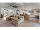 Bright and airy living room featuring tile floors, a coffered ceiling, an oversized fan, and a view of the kitchen at 9512 Mid Summer Ln, Leesburg, FL 34788