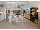 Bright living room area featuring tile floors, a coffered ceiling, and large sliding glass doors to the patio at 9512 Mid Summer Ln, Leesburg, FL 34788