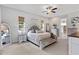 Spacious main bedroom with neutral tones, a ceiling fan, an ensuite bathroom and a walk-in closet at 9512 Mid Summer Ln, Leesburg, FL 34788